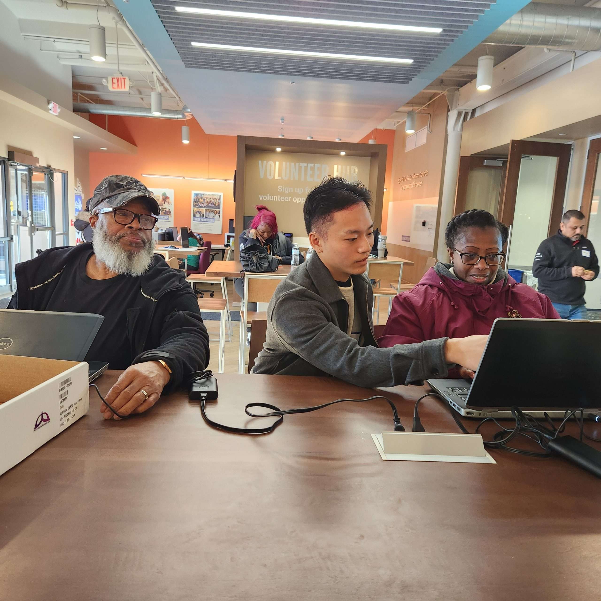 Collin Thao, a former Tech Fellow, assisting new device owners with their equipment by guiding them through permissions installation and basic functionality.
